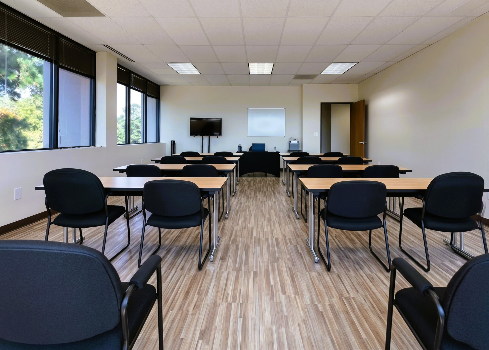 Classroom-style rows of desks and chairs facing a whiteboard in the Suite 350 meeting room